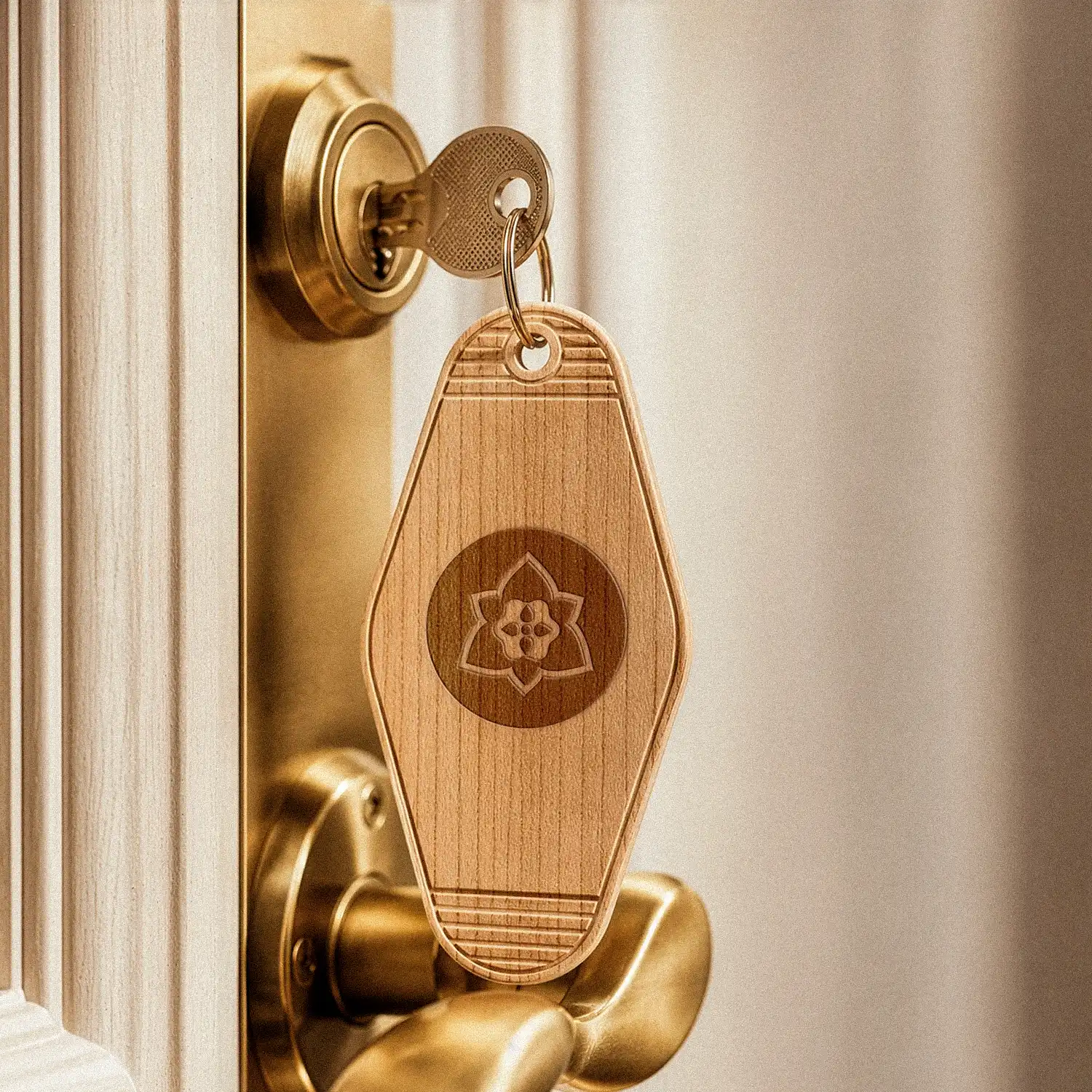 Llavero de madera grabado con el símbolo de Casería San Francisco en la puerta de una habitación